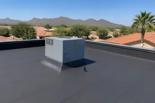 Multi-ply built-up roofing with gravel ballast and a beige stucco parapet wall in Phoenix, AZ.