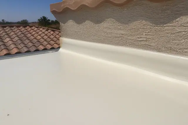 Closed-cell spray foam insulation applied to a stucco parapet wall with gravel ballast in Phoenix, AZ.