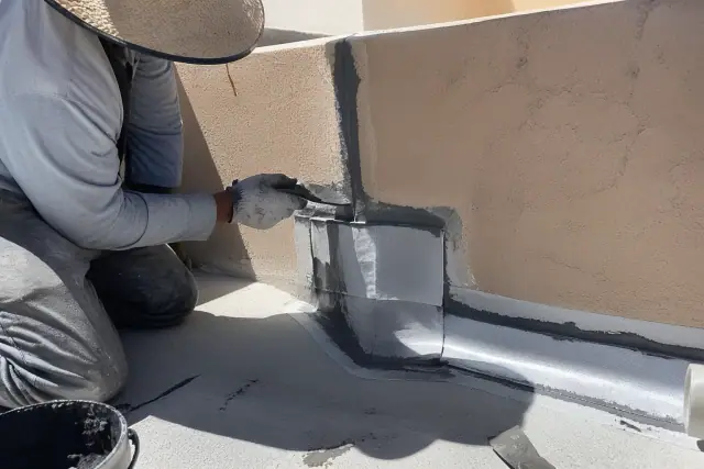 Contractors sealing a parapet wall with reinforced membrane patches during a flat roof repair in Scottsdale, AZ.