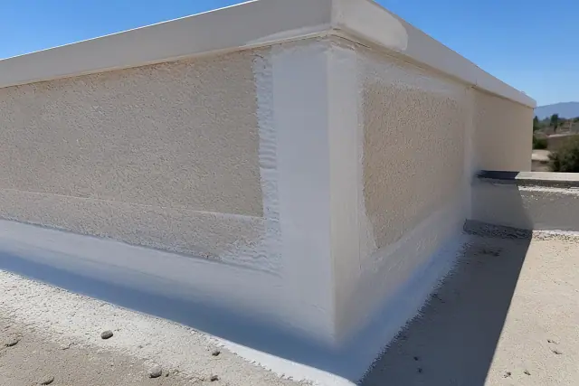 Close-up of elastomeric sealant applied to a building corner and parapet wall during a roof repair in Buckeye, AZ.