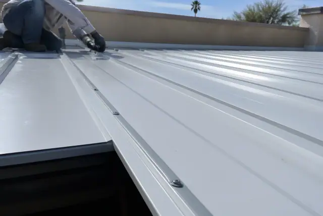 Industrial screws securing overlapping metal roofing panels on a commercial building in Glendale, AZ.