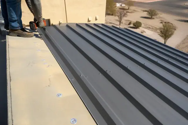 Commercial metal roofing installation with fastened overlapping steel panels at a job site in Gilbert, AZ.