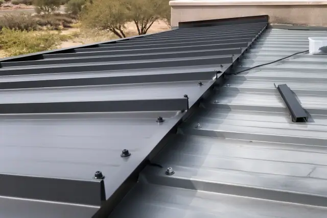 Commercial metal roofing installation showing overlapping panels and fasteners on a roof deck in Scottsdale, AZ.