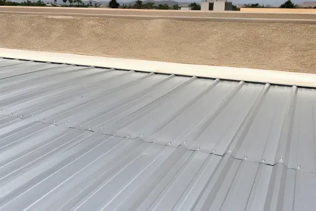 Metal roofing panels with visible screws secured on a commercial building in Mesa, AZ.