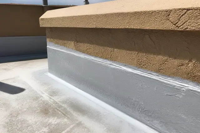 Close-up of liquid elastomeric coating on a parapet wall flashing at a commercial roof in Phoenix, AZ.