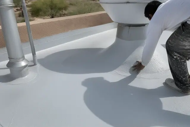 Technicians applying a seamless liquid membrane around a rooftop ventilation unit in Peoria, AZ.