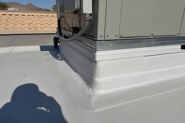 Technician inspecting a multi-layered roof membrane seam on a ventilation unit in Phoenix, AZ.