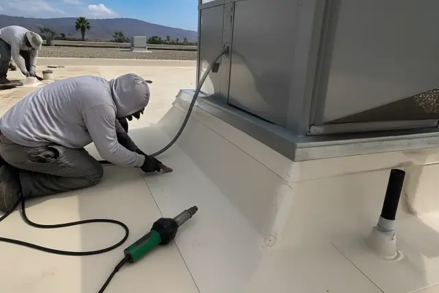 Technicians performing roof membrane detailing near a ventilation unit in Scottsdale, AZ.