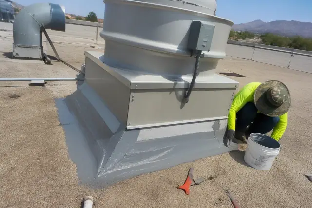 Technicians repairing a roof membrane around an HVAC unit on a commercial building in Goodyear, AZ.