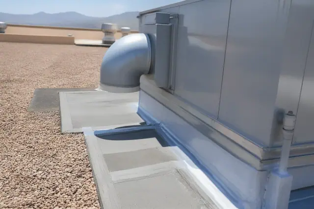 Roofing membrane detailing around an HVAC unit on a gravel roof in Goodyear, AZ with the Estrella Mountains in view.