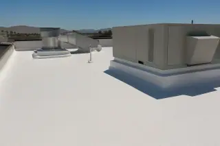 Wide view of a reflective white roof and ventilation unit under bright sunlight in Phoenix, AZ.