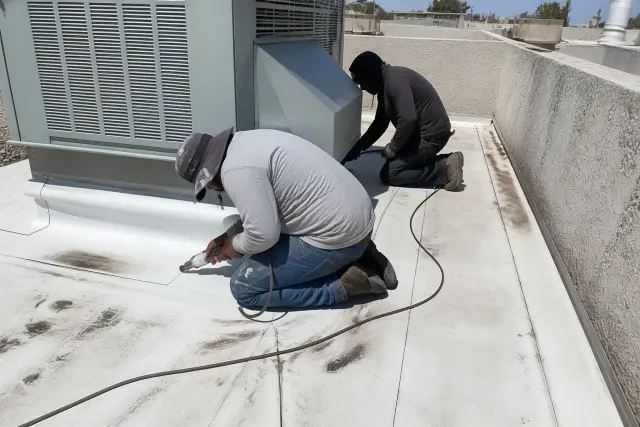 Contractors performing TPO membrane roof repairs around an HVAC unit in Buckeye, AZ.