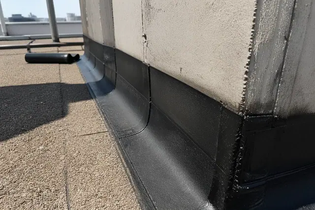 Close-up of a modified bitumen roof replacement with heat-welded seams on a parapet wall in Phoenix, AZ.
