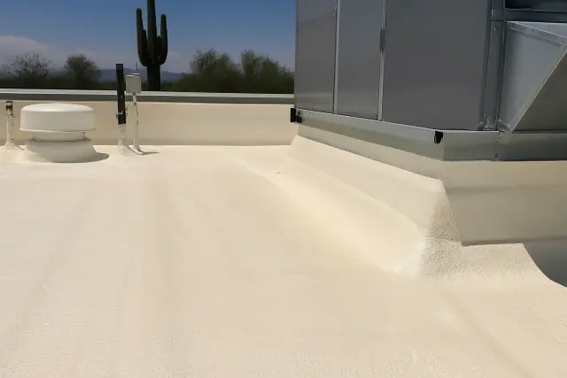 Spray foam roofing transition around a rooftop HVAC unit with a view of a saguaro cactus in Phoenix, AZ.
