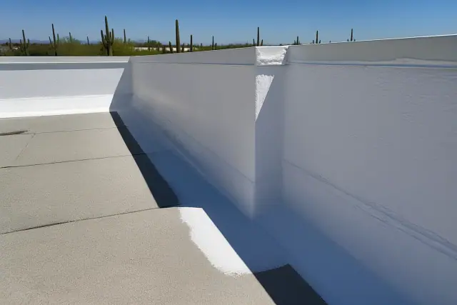 White elastomeric coating applied to parapet wall flashing on a commercial roof in Phoenix, AZ.
