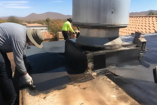 Technicians repairing a torn roof membrane on a sun-bleached terracotta roof in Phoenix, AZ after storm damage.