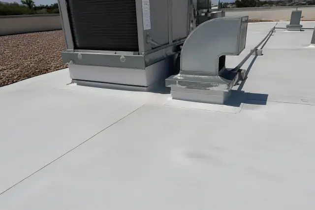 Fastener backout distorting a TPO roof membrane near an HVAC unit on a sunny rooftop in Phoenix, AZ.