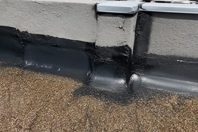 Close-up of industrial sealant repair on a parapet wall flashing at a commercial flat roof site in Phoenix, AZ.