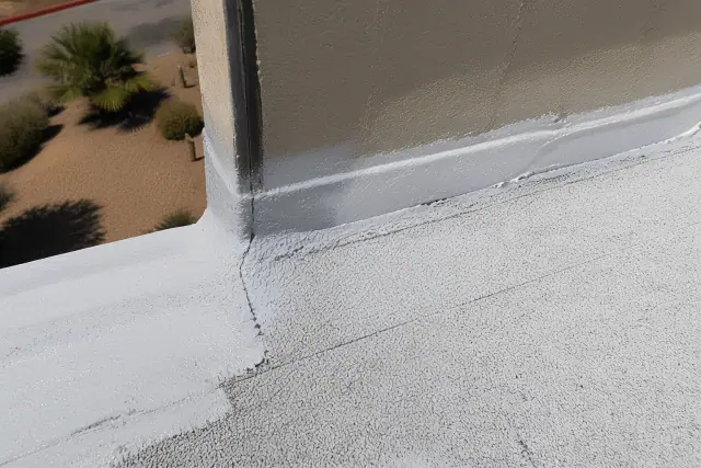 Close-up of a modified bitumen roof parapet with reflective coating and granulated finish in Phoenix, AZ.