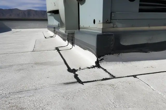 Heat-welded seams on a modified bitumen roof near a ventilation unit with desert mountains in the background, Phoenix, AZ.
