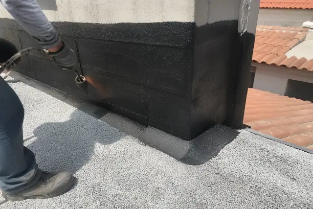 Contractor installing modified bitumen roofing on a parapet wall in Phoenix, AZ.