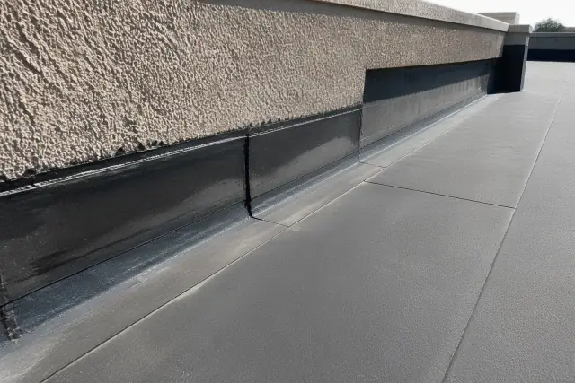 Modified bitumen roofing installation with smooth seams and sealant at a parapet wall in Chandler, AZ.
