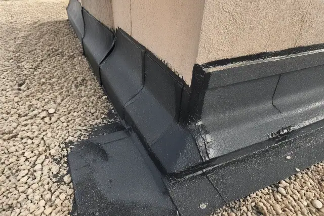 Modified bitumen membrane seams with bitumen bleed-out along a rooftop parapet wall in Phoenix, AZ.