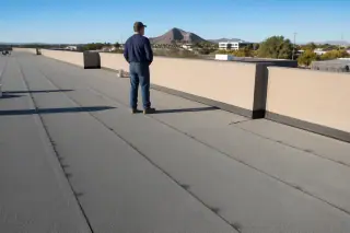 Granulated modified bitumen roofing with sealed parapet flashing and desert dust on a commercial roof in Phoenix, AZ.