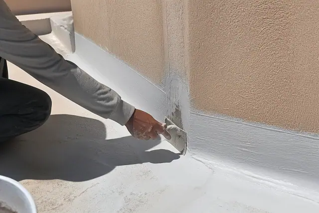 Contractors applying elastomeric coating to a parapet wall on a commercial roof in Phoenix, AZ.