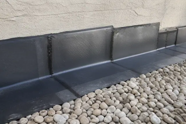 SBS modified bitumen roofing with heat-welded seams at a stucco parapet wall in Phoenix, AZ, with river rock ballast.