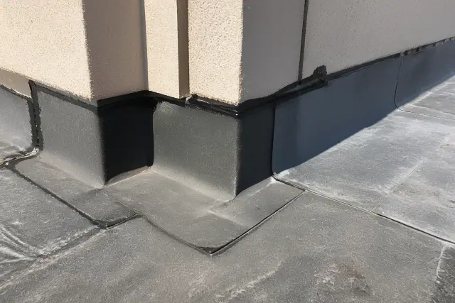 Self-adhering membrane installed on a stucco parapet wall under bright sunlight in Phoenix, AZ.