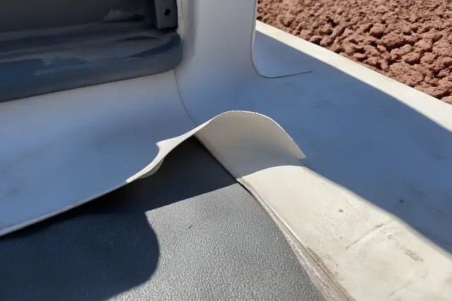 Separated heat-welded TPO roof seam with curled white membrane edge on a jobsite in Phoenix, AZ.