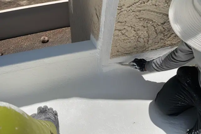 Spray foam and reflective roof coating applied to a parapet wall corner in Phoenix, AZ.