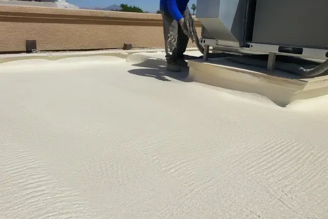 Spray foam roofing texture with ripple patterns near a rooftop HVAC unit and stucco wall in Phoenix, AZ.