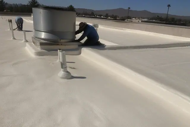 A layer of spray foam roofing applied to a gravel rooftop with desert mountains in the background in Goodyear, AZ.