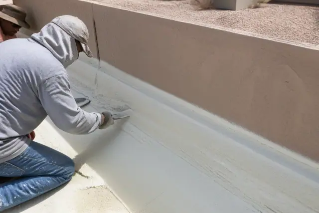 Spray foam insulation applied to a commercial parapet wall and roof transition in Gilbert, AZ.