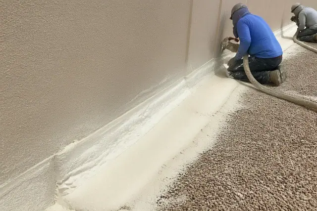 Spray foam roofing application along a parapet wall during a commercial roof maintenance project in Phoenix, AZ.