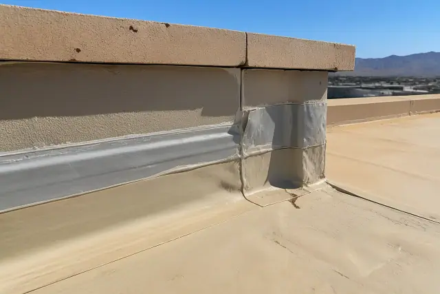 Close-up of a synthetic roofing membrane and sealant on a parapet wall during a commercial roof inspection in Phoenix, AZ.