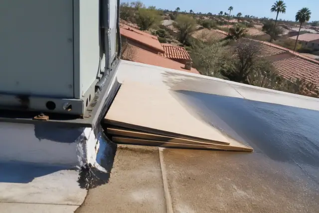 Tapered insulation directing water runoff away from a rooftop HVAC unit on a flat membrane roof in Phoenix, AZ.