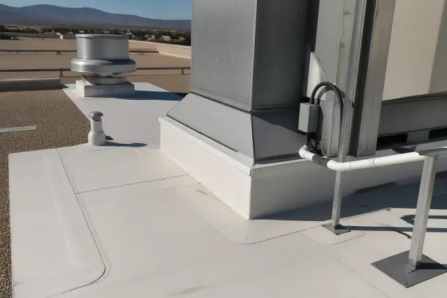 Technicians performing TPO membrane detailing on a commercial roof in Phoenix, AZ with heat-welded seams.