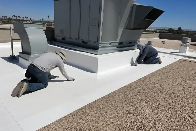 Technicians installing TPO membrane roofing around a ventilation unit on a gravel rooftop in Mesa, AZ.