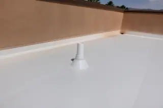Molded rubber boot flashing sealed around a plumbing vent pipe on a white TPO roof in Phoenix, AZ.