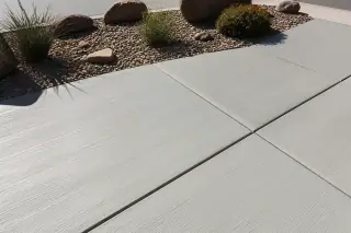 Broom-finished concrete slab with sharp control joints and desert landscaping in Phoenix, AZ.