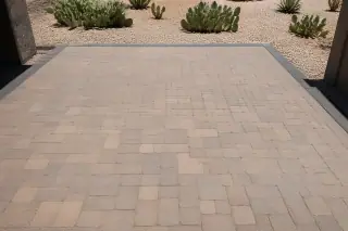 Completed interlocking concrete paver patio with desert gravel and prickly pear cacti in Phoenix, AZ.