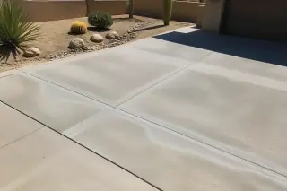 Concrete repair with clean patches and sealed joints near xeriscaped landscaping in Phoenix, AZ.