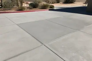 Cured concrete patch with straight control joints and desert xeriscaping in Phoenix, AZ.
