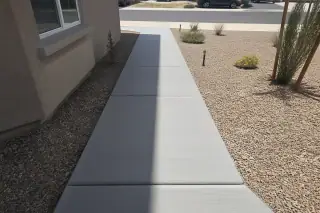 Clean cured concrete sidewalk with a broom-brushed texture and desert landscaping in Phoenix, AZ.