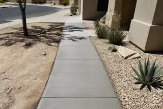 Finished concrete walkway with a broom-brushed texture and desert landscaping in Phoenix, AZ.