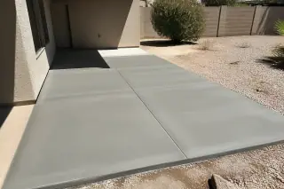 Cured concrete slab with crisp control joints near a stucco house in Phoenix, AZ.