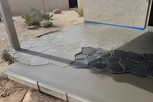 Contractor finishing a stamped concrete patio with prickly pear cacti in Phoenix, AZ.